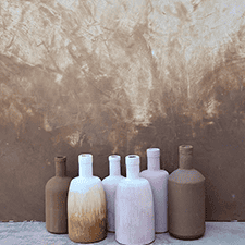 Decorative paint finish with painted bottles against textured wall